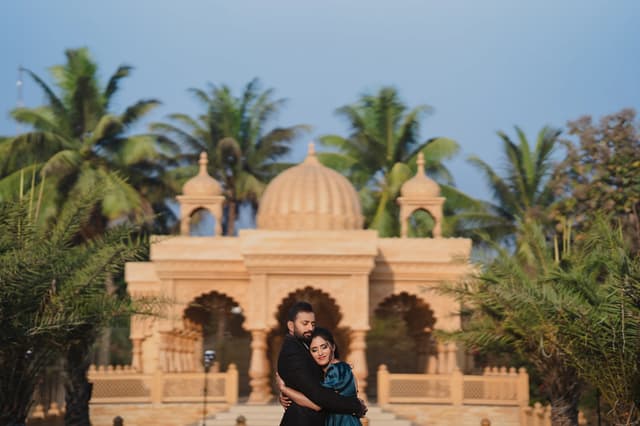 Couple seated beneath palace arches surrounded by palm trees