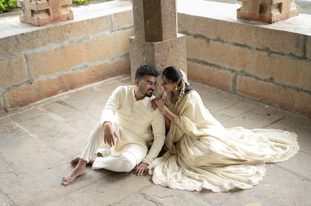 Couple seated together on stone steps in soft neutral light