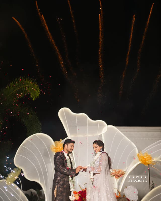 Couple standing together beneath fireworks during an engagement event