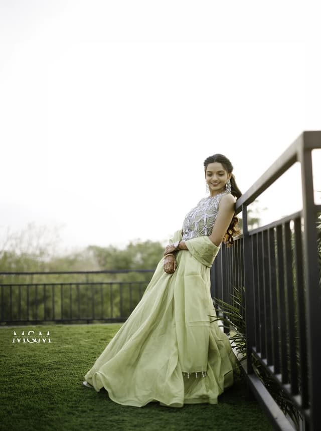 Bride standing on an outdoor walkway in a pale green engagement outfit
