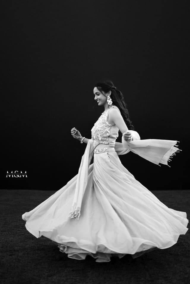 Black and white portrait of a bride twirling in an engagement dress