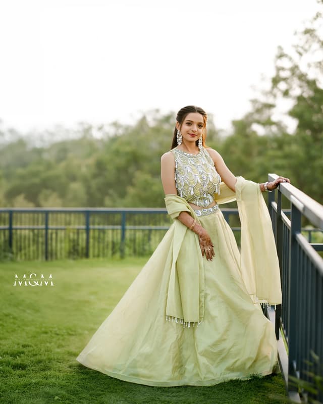 Bride standing outdoors in a flowing pale green engagement outfit