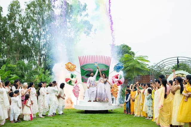 Haldi celebration with dancers, smoke and drummers in a garden