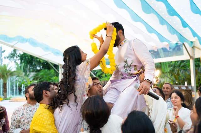 Groom seated above the crowd during a lively Haldi celebration