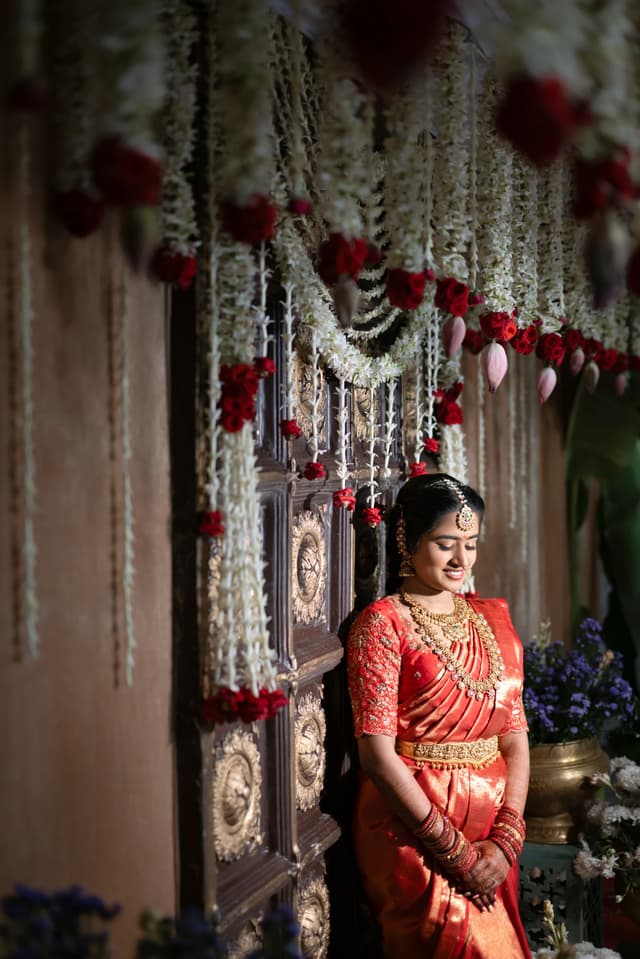 Bride seated beneath floral decor during a Pellikuthuru portrait