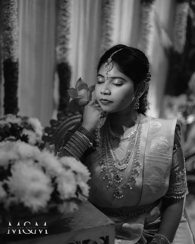 Black and white seated bridal portrait with flowers in the foreground