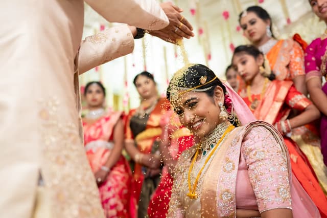 Bride smiling during a wedding ceremony as family gathers around