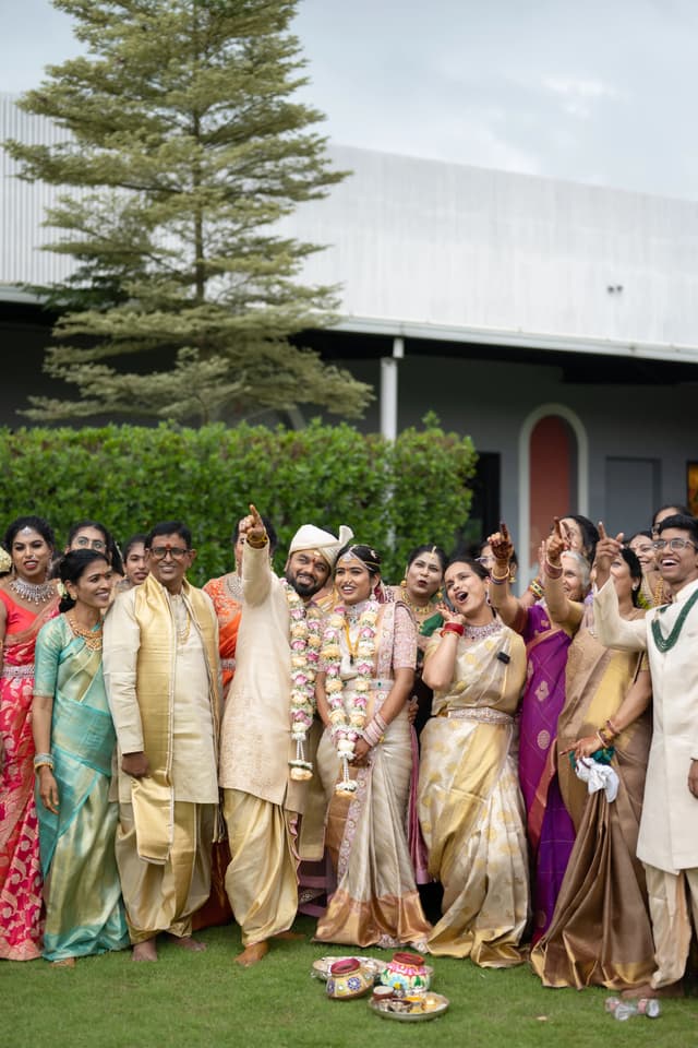 Wedding family group gathered outdoors with the couple