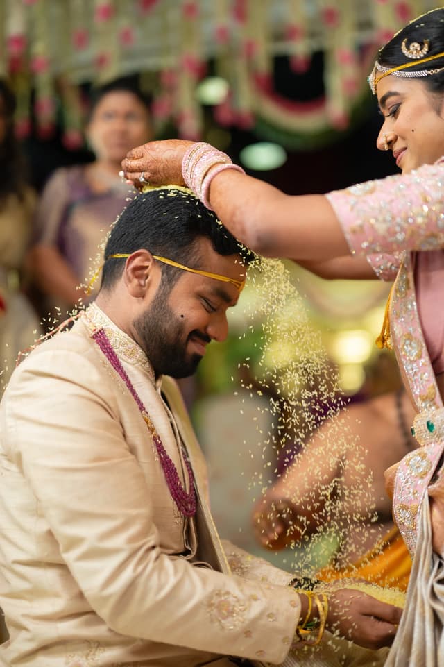 Groom receiving turmeric during a joyful wedding ceremony moment